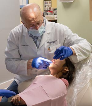 Rotarian and dentist Dr. Gabe Rich examines a patient at free dental clinic